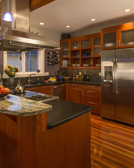 Kitchen remodel in warm wood cabinetry with stone counters and stainless appliances