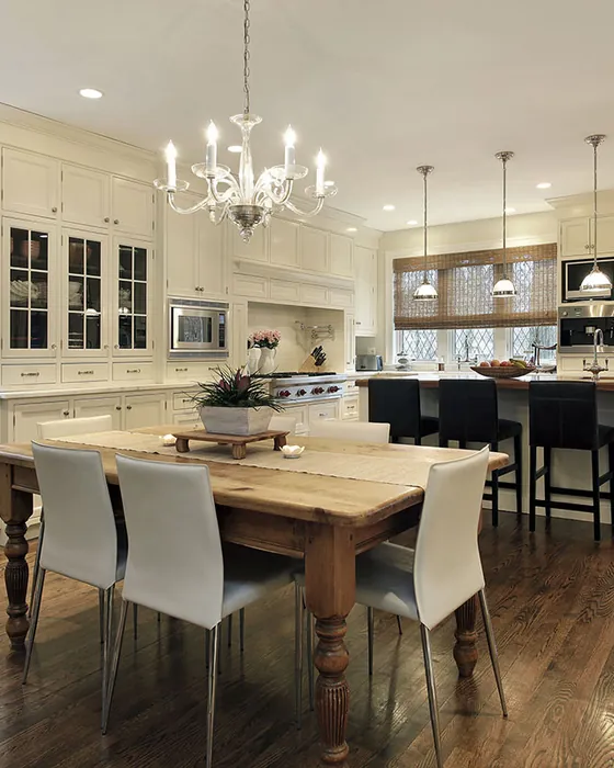 Open kitchen and dining area with a chandelier, island seating and hardwood floors